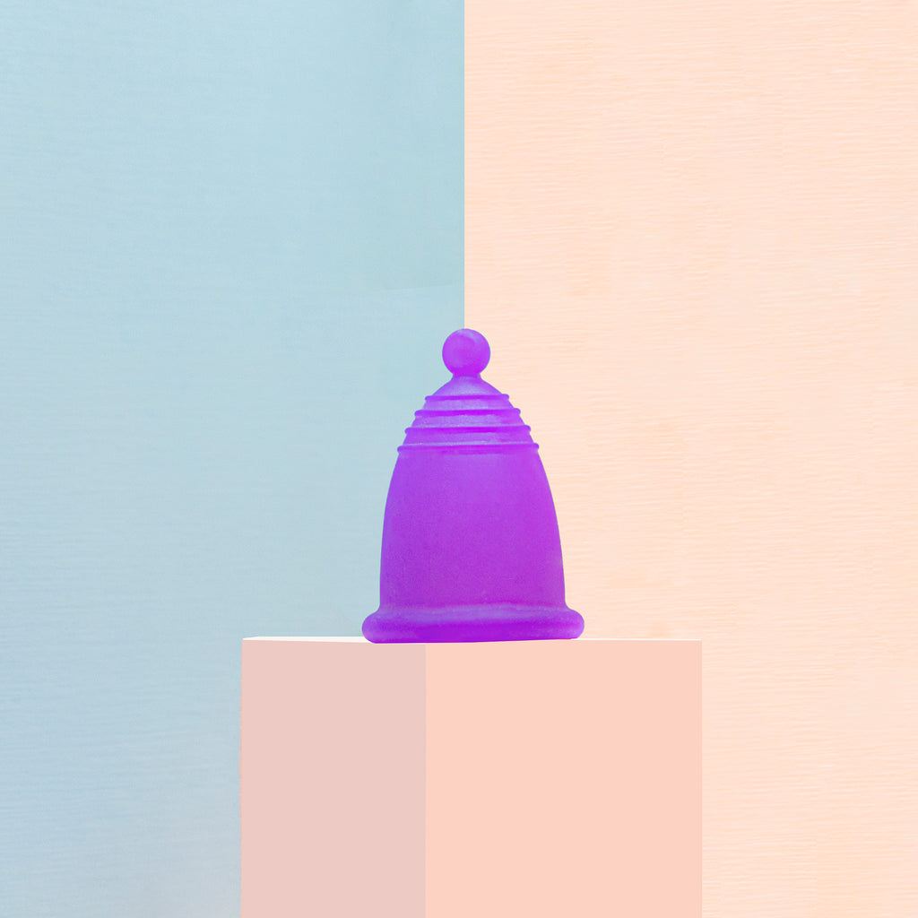 Una copa menstrual morada en tallas especiales: chica, mediana y grande